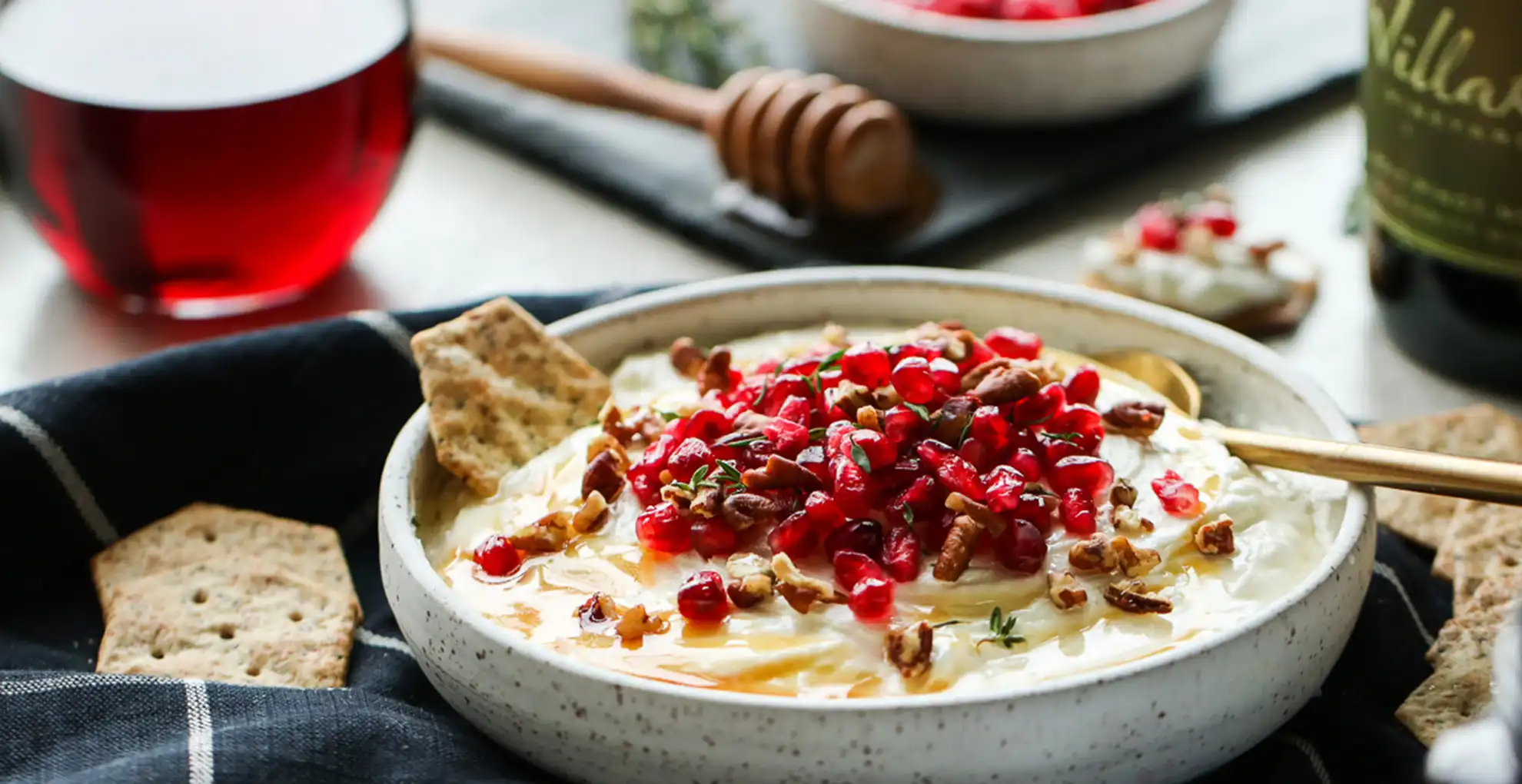 honey whipped goat cheese in bowl with glass of wine