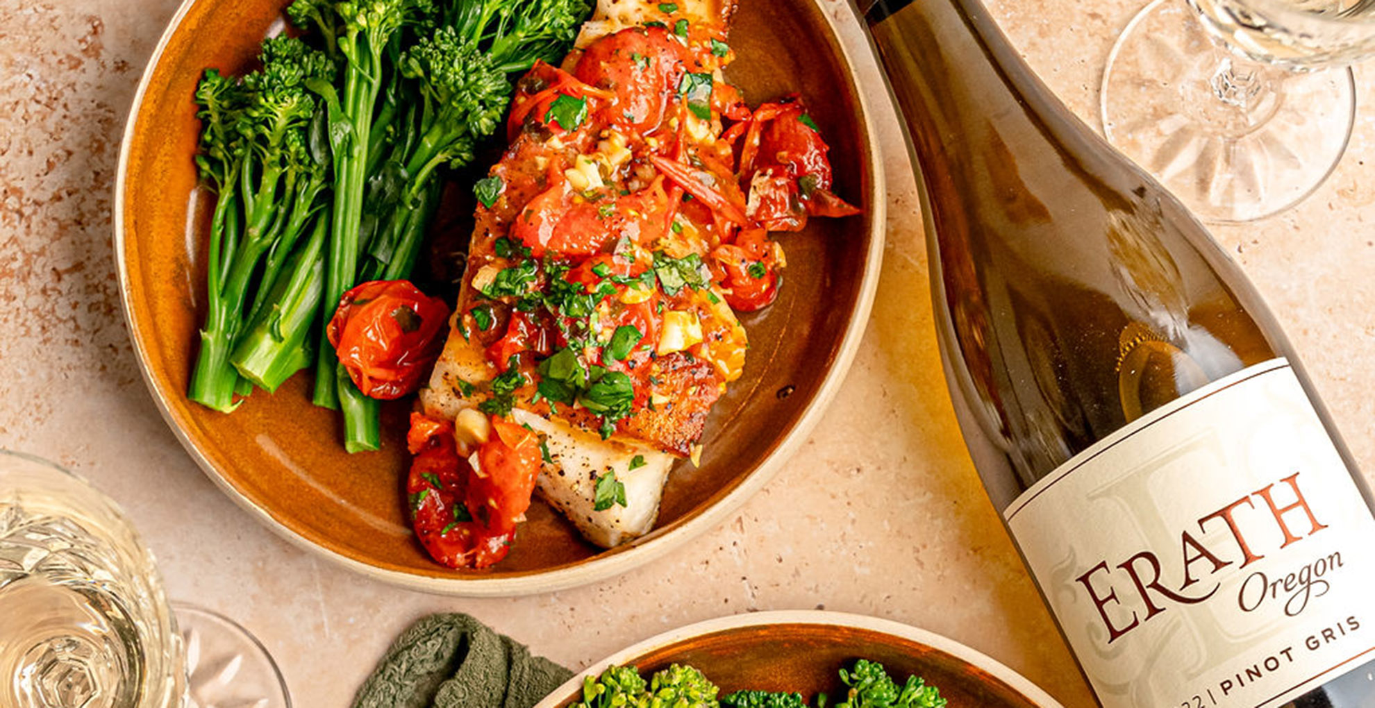 sea bass cherry tomato sauce and broccolini, next to erath oregon pinot gris bottle and wine glass