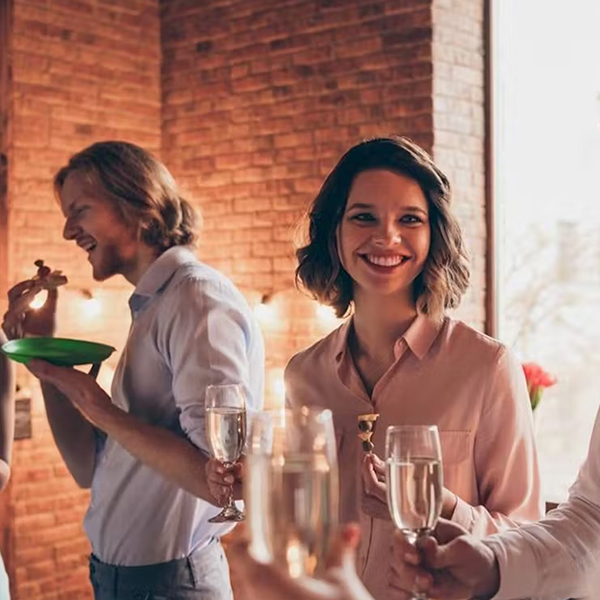 woman and man in tasting room, man eating food woman holding wine glass