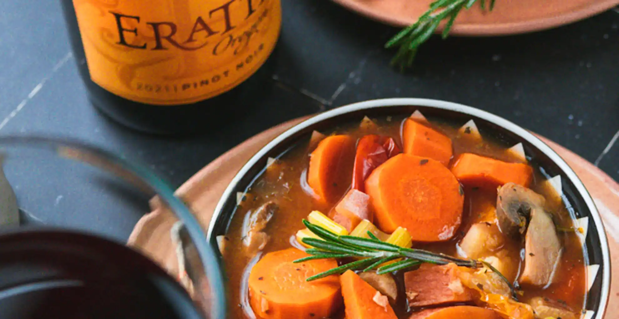 vegatable stew in bowl with erath pinot noir bottle