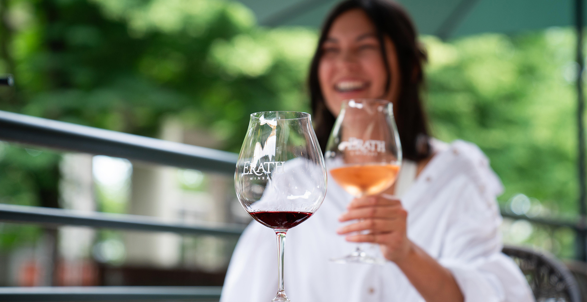 woman with erath wine glasses outside at table