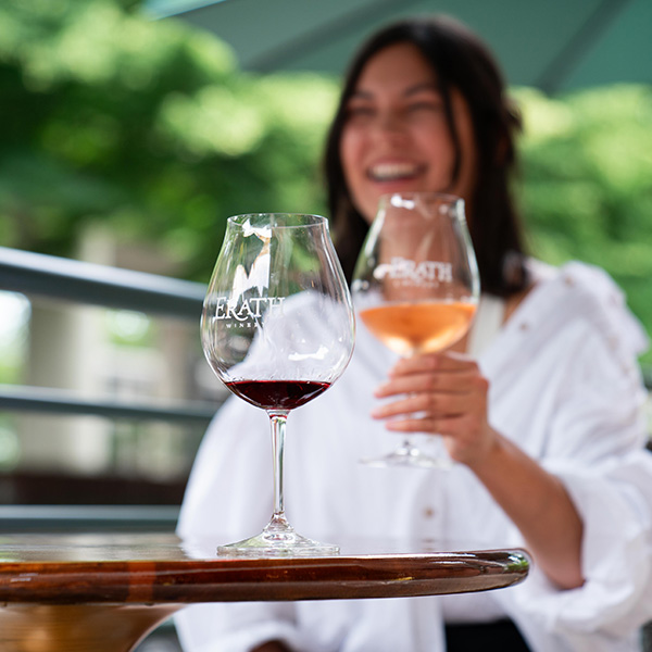 woman with erath wine glasses outside at table