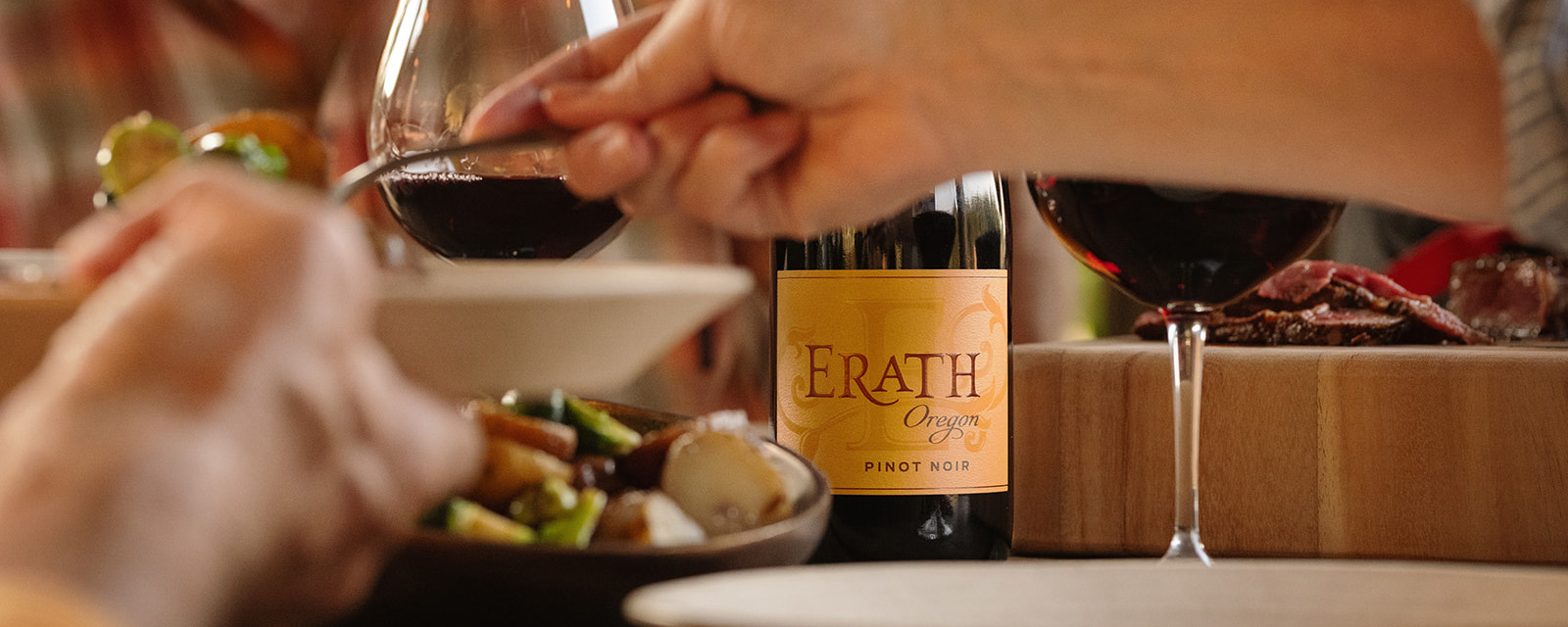 erath oregon pinot noir label in focus on table behind a bowl of food at dinner