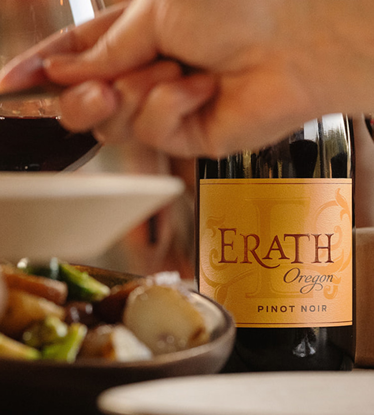 erath oregon pinot noir label in focus on table behind a bowl of food at dinner