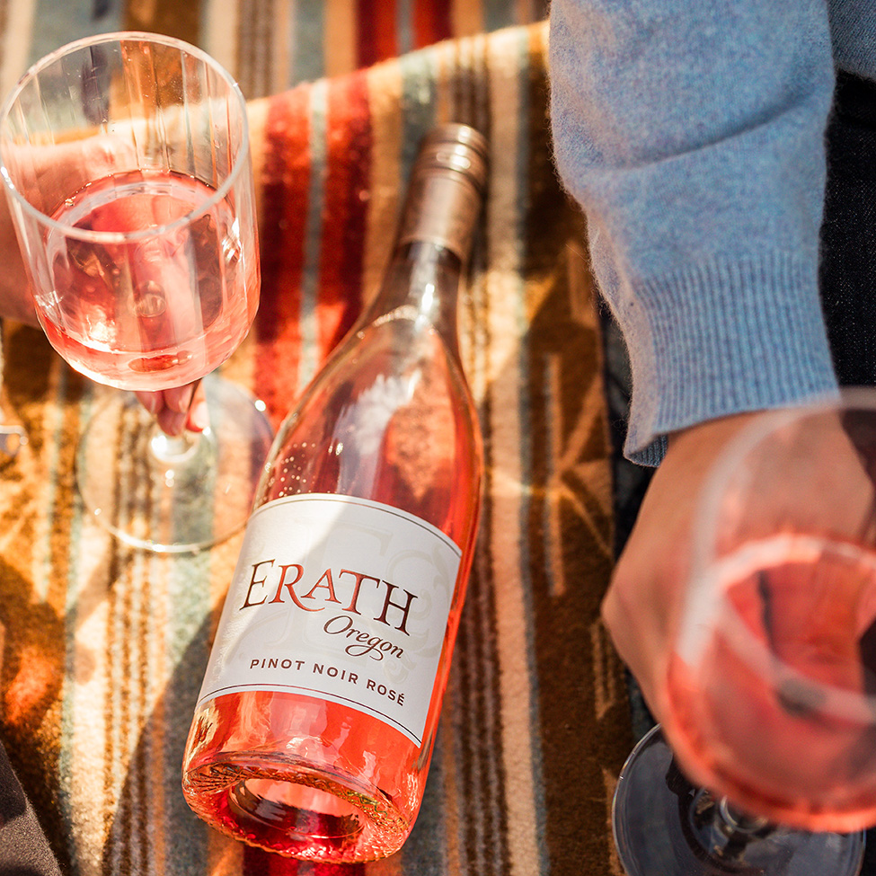 erath oregon pinot noir rose on blanket with glasses, women holding glass