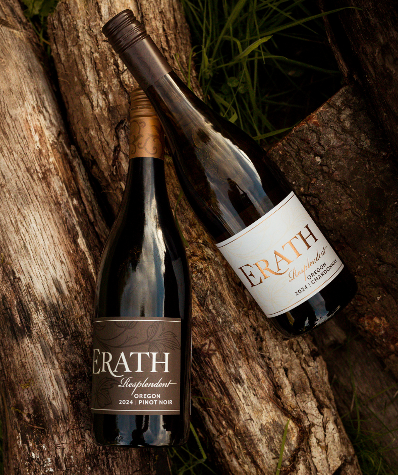 A bottle of 2024 Erath Resplendent Chardonnay and 2024 Erath Resplendent Pinot Noir resting on some wood.