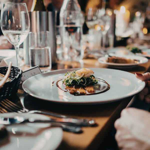 A gourmet plate of food sits on a dinner table.